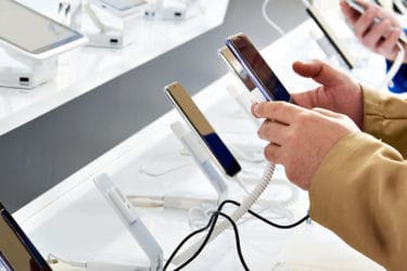 Buyer hands with mobile smartphones in electronics store